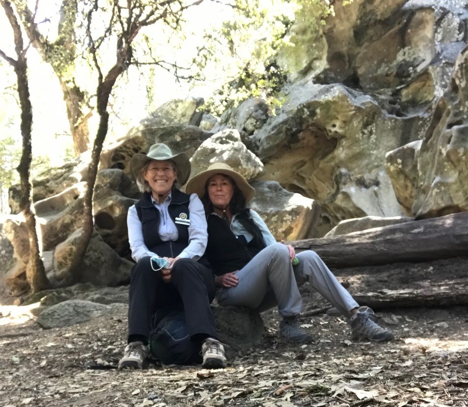 Two female volunteers sitting together on a break while patrolling the trails at Castle Rock SP